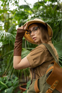 Portrait of woman wearing hat against trees