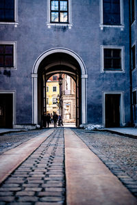 People walking on footpath amidst buildings