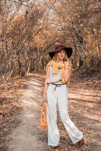 Portrait of woman standing by tree