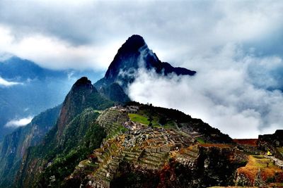 Scenic view of machu picchu and mountains against cloudy sky