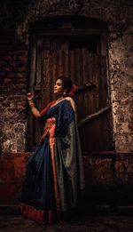 Portrait of woman standing in abandoned house