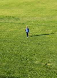 High angle view of boy walking on grassy field