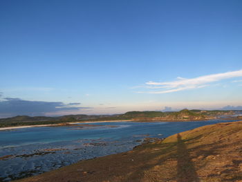 Scenic view of beach against blue sky