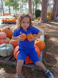 Portrait of boy sitting against bright sun