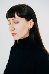 Close-up portrait of young woman against white background