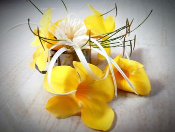 Close-up high angle view of yellow flowers on table