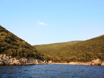 Scenic view of sea and mountains against clear sky