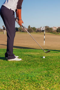 Low section of man standing on golf course