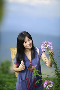 Woman standing on purple flowering plant