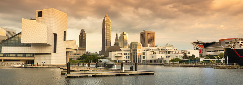 Buildings by river against sky in city