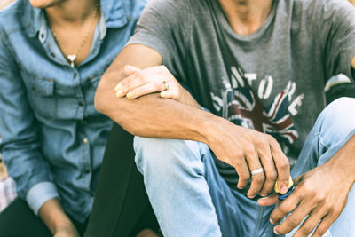 Midsection of couple sitting outdoors