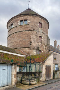 Low angle view of old building against cloudy sky