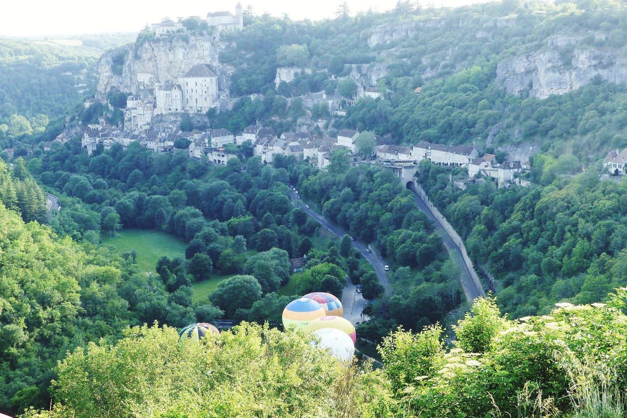 REAR VIEW OF MAN AND WOMAN AGAINST MOUNTAIN