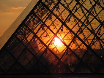 Low angle view of silhouette built structure against sunset sky