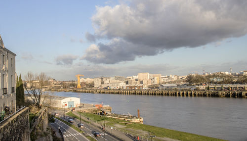 High angle view of river by buildings in city against sky