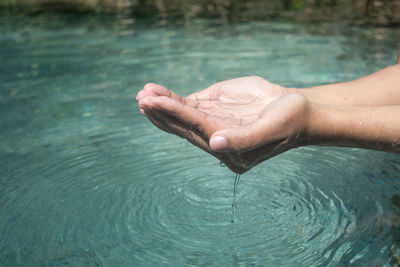 Cropped image of person holding water in hand