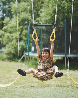 Boy swinging at playground