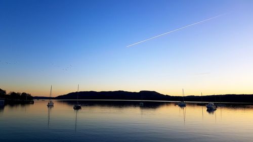 Scenic view of vapor trails against clear sky during sunset