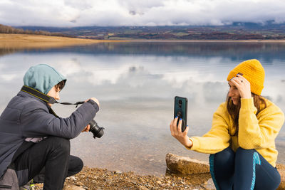 Mother and son spend time together in front of a lake in the mountains taking pictures