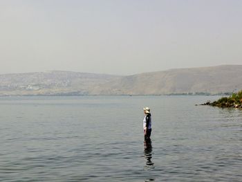 Man standing in sea against clear sky