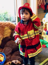 Cute boy looking away while standing at toy