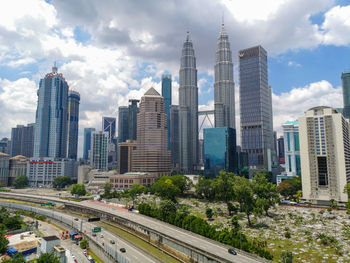 View of buildings in city against cloudy sky