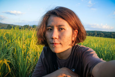 Portrait of woman on field against sky