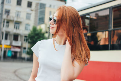 Portrait of beautiful woman standing against building