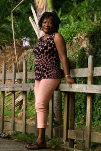 Portrait of mature woman standing by railing