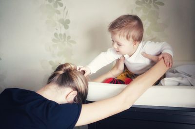 Mom playing with cute baby boy at home