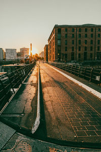 Railroad tracks by buildings in city against clear sky