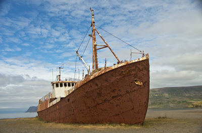 Abandoned ship by sea against sky