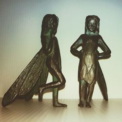 Close-up of figurine on table against wall