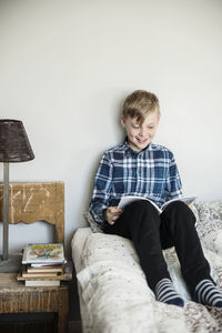 Smiling boy reading on bed