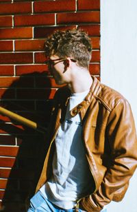 Midsection of man standing against brick wall