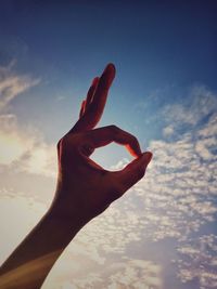 Close-up of hand against sky