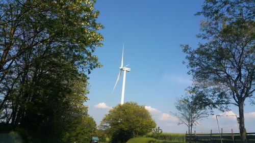 Low angle view of windmill against blue sky