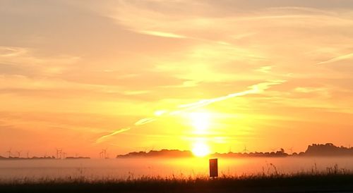 Scenic view of sunset over field