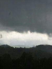 Scenic view of mountains against cloudy sky