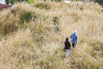 Rear view of people walking on field