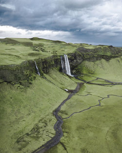 Scenic view of waterfall and mountain against sky