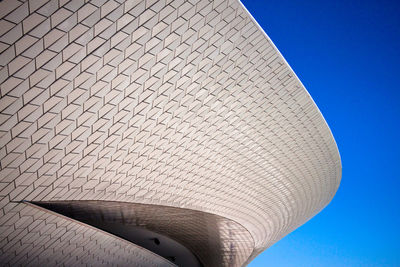 Low angle view of modern building against blue sky