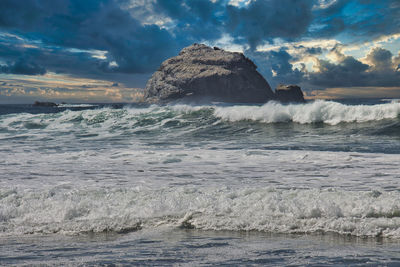 Rocks in sea against sky