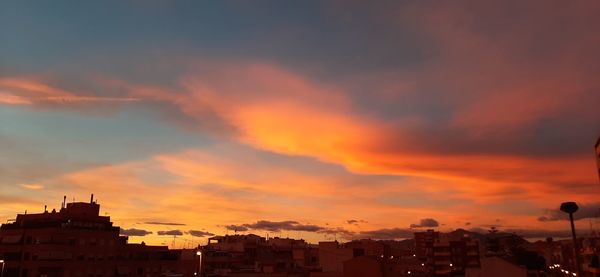 Silhouette buildings against sky during sunset