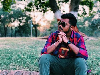 Young man sitting at park