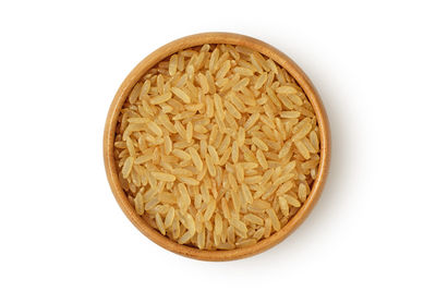 Brown rice in wooden bowl on white background