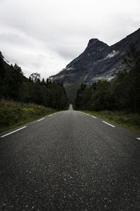 Surface level of road amidst mountains against sky