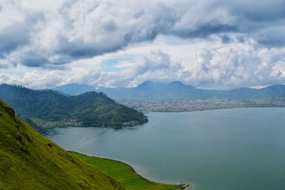 Scenic view of sea and mountains against sky