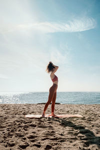 Full length of woman on beach against sky