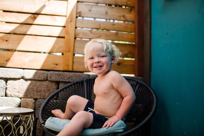 Two year old sitting in chair smiling for camera